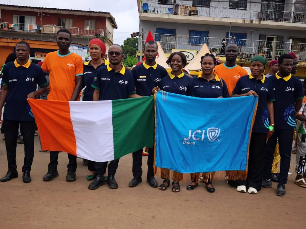 Des membres de la JCI Dabou réunis avec les drapeaux ivoirien et JCI