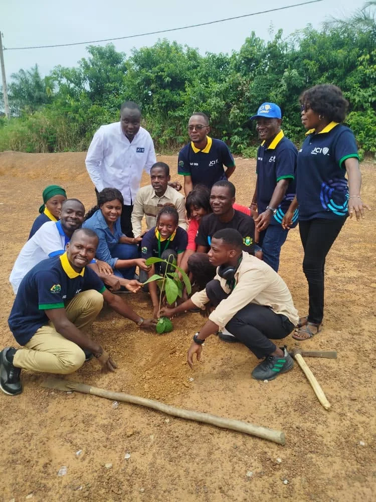 Participants réunis autour d’un jeune arbre planté pendant l’activité